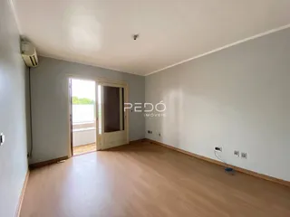 Ambiente interno de uma sala com piso de madeira clara.