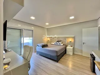 Quarto moderno com cama e porta de vidro.