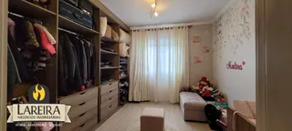 Interior de uma sala com estantes de madeira e decoração floral na parede.