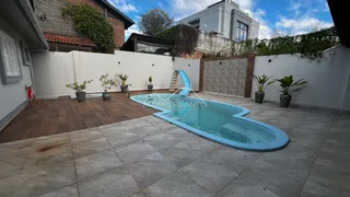 Foto da área externa com piscina e jardim de uma residência em Lajeado.