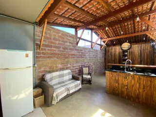 Sala com sofá e parede de tijolos aparentes em um ambiente rústico.