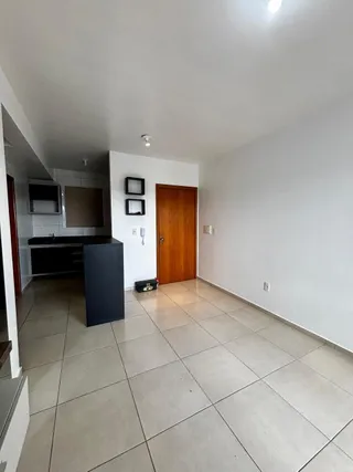 Cozinha com piso de cerâmica e armários escuros em ambiente interno.