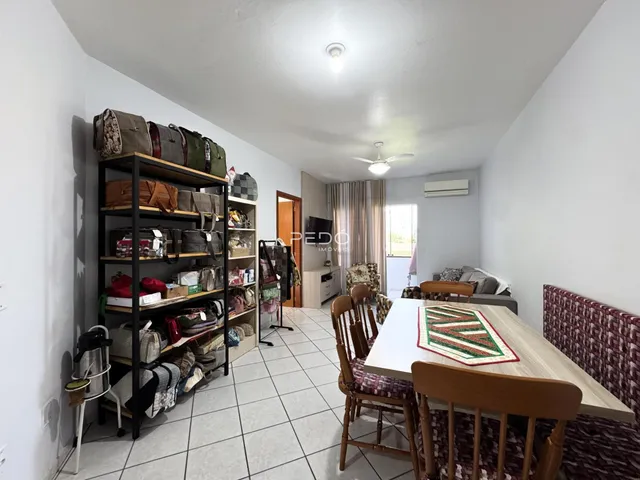 Ambiente interno de uma sala com estantes e mesa de jantar.