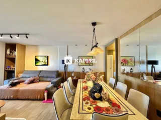 Sala de estar com sofá e mesa de jantar em ambiente moderno.