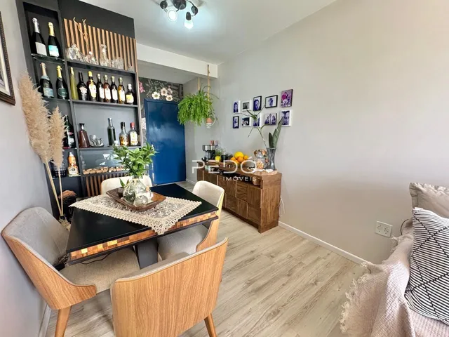 Sala de estar com estantes e mesa de jantar em um apartamento no Brasil.