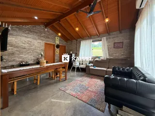 Sala de estar com teto de madeira e sofá de couro marrom.