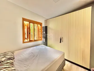 Quarto com armário embutido e piso de madeira clara.