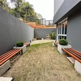 Área externa com muro e piso de madeira visível.
