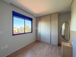 Um cômodo interno com grande janela e armários embutidos.