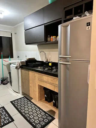 Foto de uma cozinha com armários escuros e bancada preta.