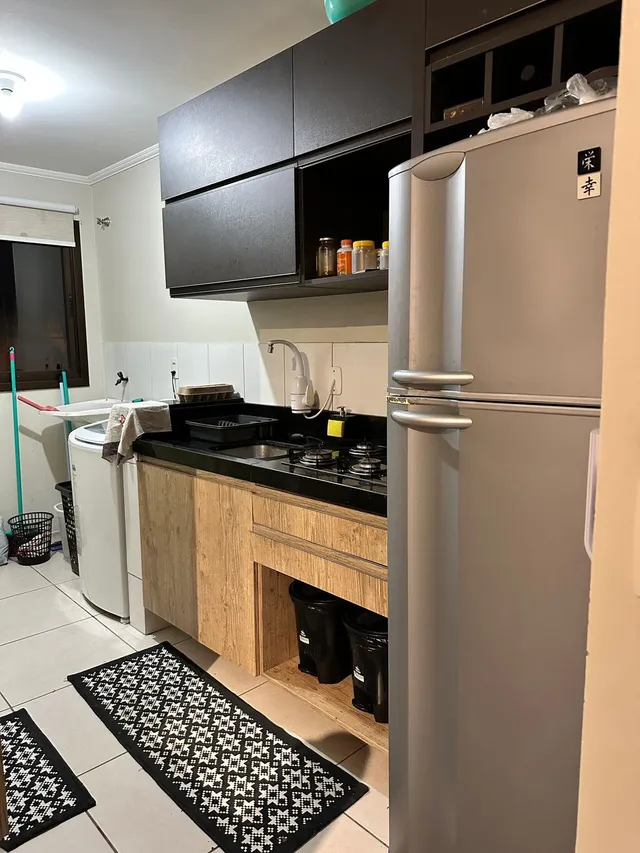 Foto de uma cozinha com armários escuros e bancada preta.