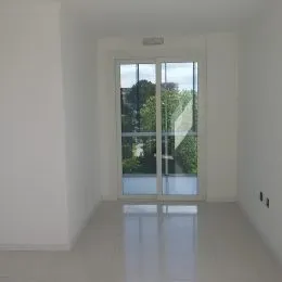 Hall de entrada com portas de vidro que dão para o exterior.