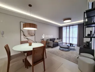 Sala de estar com mesa redonda e cadeiras em ambiente claro.