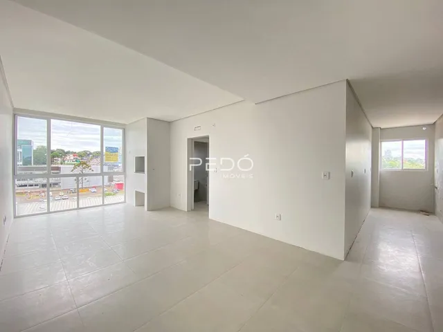 Ambiente interno com paredes brancas e grande janela.