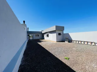 Fachada externa de uma residência em Lajeado, Brasil, com área externa de cascalho.