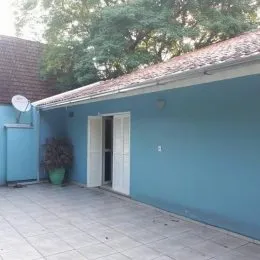 Fachada externa de uma residência azul com piso de concreto em Lajeado.