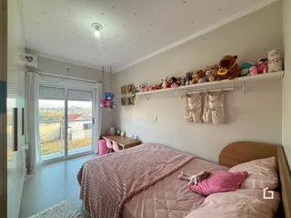 Quarto com cama e janela de vidro em imóvel no Brasil.