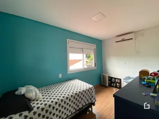 Quarto com parede azul e janela de madeira.