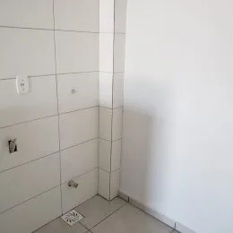 Vista de uma parede interna com revestimento branco em um ambiente residencial.
