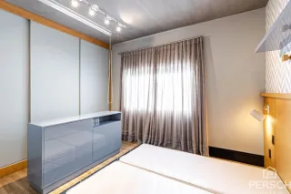 Um quarto com cama e armários embutidos é mostrado na foto.