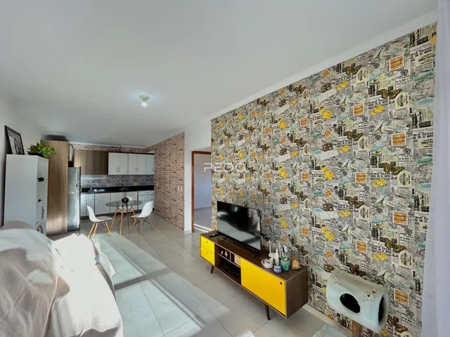 Ambiente interno de uma sala com parede decorada com papel de parede em Lajeado.