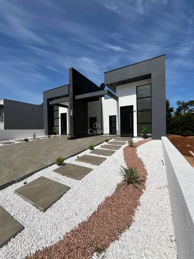 Fachada moderna de uma casa em Lajeado, Brasil, com paisagismo frontal.