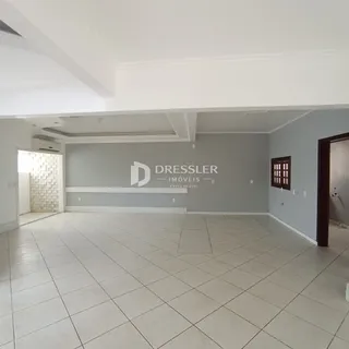 Ambiente interno de uma área com piso de cerâmica e paredes cinzas.