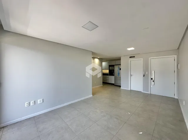 Vista de um corredor amplo com piso de cerâmica em uma residência.