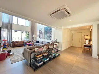 Sala de estar ampla com grandes janelas e decoração moderna.