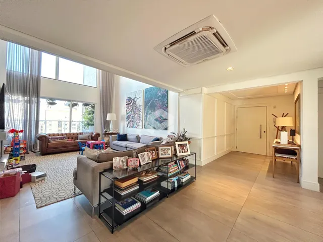 Sala de estar ampla com grandes janelas e decoração moderna.