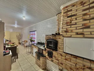 Sala de jantar e cozinha com parede de tijolos aparentes.