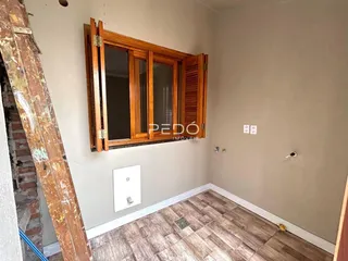 Foto de um cômodo interno com piso de cerâmica e molduras de madeira.