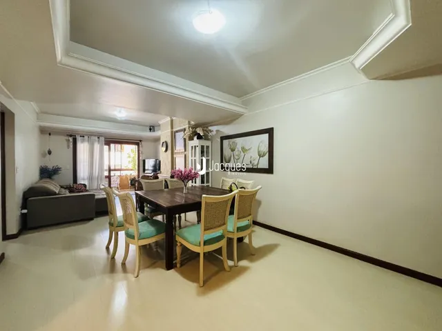 Sala de estar com mesa de jantar e sofá em ambiente interno.