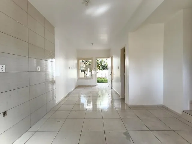 Corredor com paredes brancas e piso de cerâmica.