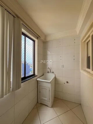 Banheiro com piso de cerâmica e paredes brancas.
