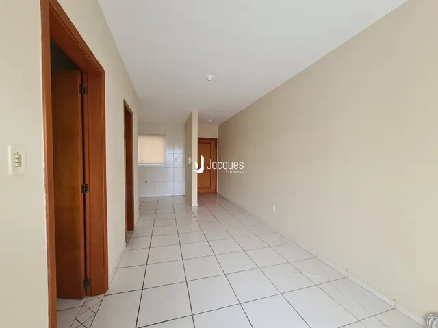 Corredor interno com piso de cerâmica e paredes claras.
