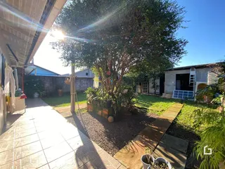 Vista externa de uma propriedade com jardim e calçada.