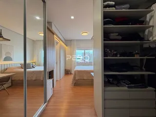 Quarto com armário grande e piso de madeira em um imóvel no Brasil.