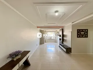 Hall de entrada com piso claro e paredes brancas.
