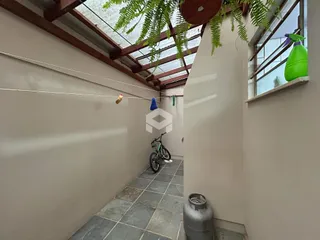 Corredor interno com teto inclinado e janela no final