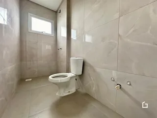 Foto de um banheiro com revestimento de azulejos claros.