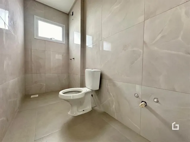 Foto de um banheiro com revestimento de azulejos claros.