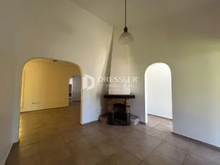 Interior de uma sala com paredes brancas e piso de cerâmica.