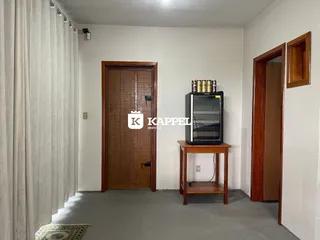 Foto de um ambiente interno com porta de madeira e um refrigerador preto.