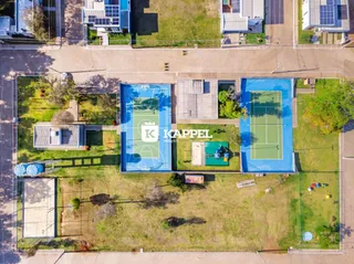 Vista aérea de um terreno com piscina e quadras de tênis.