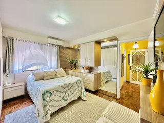 Foto de um quarto com cama e piso de madeira em uma propriedade em Lajeado, Brasil.
