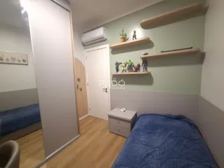 Quarto com paredes verdes e piso de madeira.