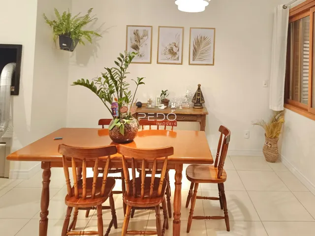Foto de uma sala de jantar com mesa de madeira e cadeiras.