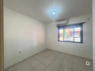 Ambiente interno de uma sala com piso de cerâmica e ar-condicionado instalado.