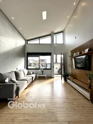 Sala de estar moderna com piso de madeira clara e grandes janelas.